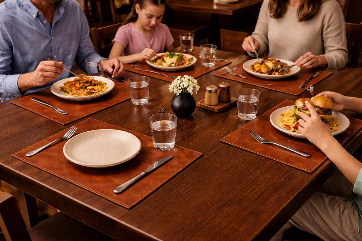 Brown leather placemats arranged with plates and cutlery for a family meal.