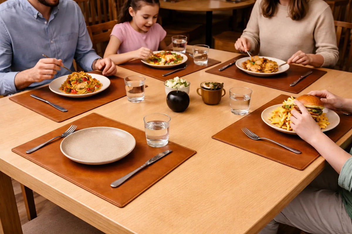Warm brown leather placemats on a light wood table during a family meal.